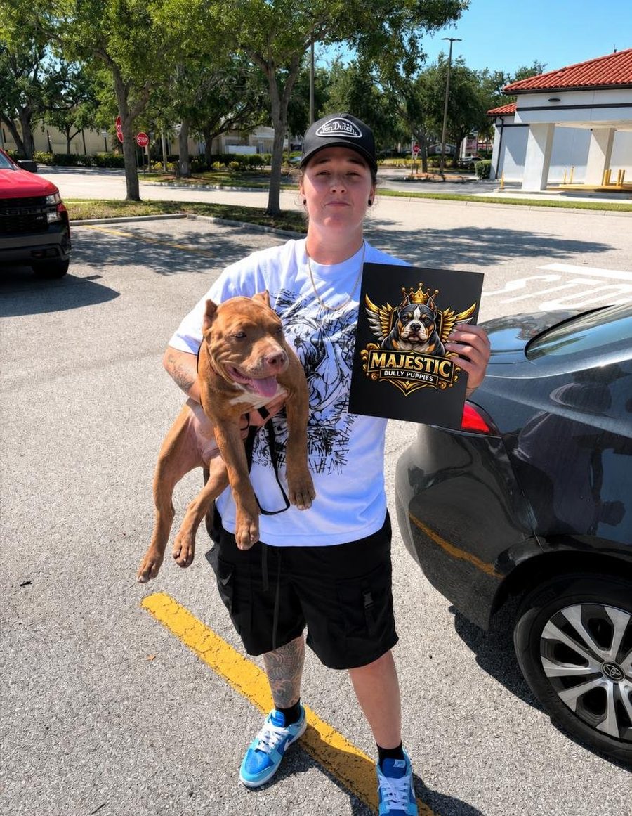 A new owner in Florida holding her red American Bully after collecting it